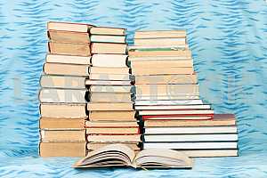 Old and used hardback books or text books on wooden table. Books and reading are essential for self improvement, gaining knowledge and success in our careers, business and personal lives. Copy space