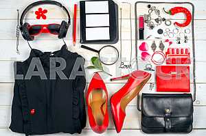 Women clothing set and accessories on white wooden background.