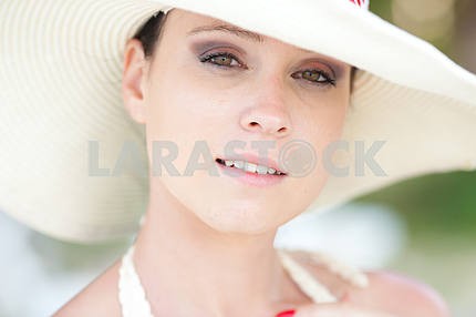 Portrait of beautiful young girl in white hat